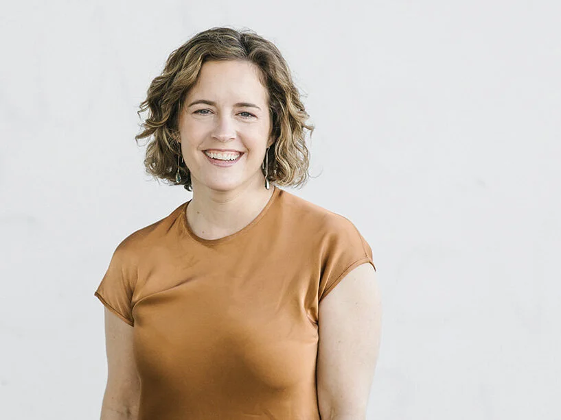 Kate Lingoni, Fractional COO smiling in a brown shirt against a light background.